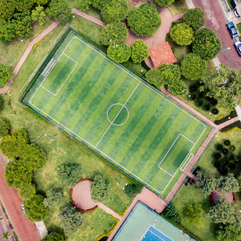 An aerial view of a soccer field surrounded by trees
