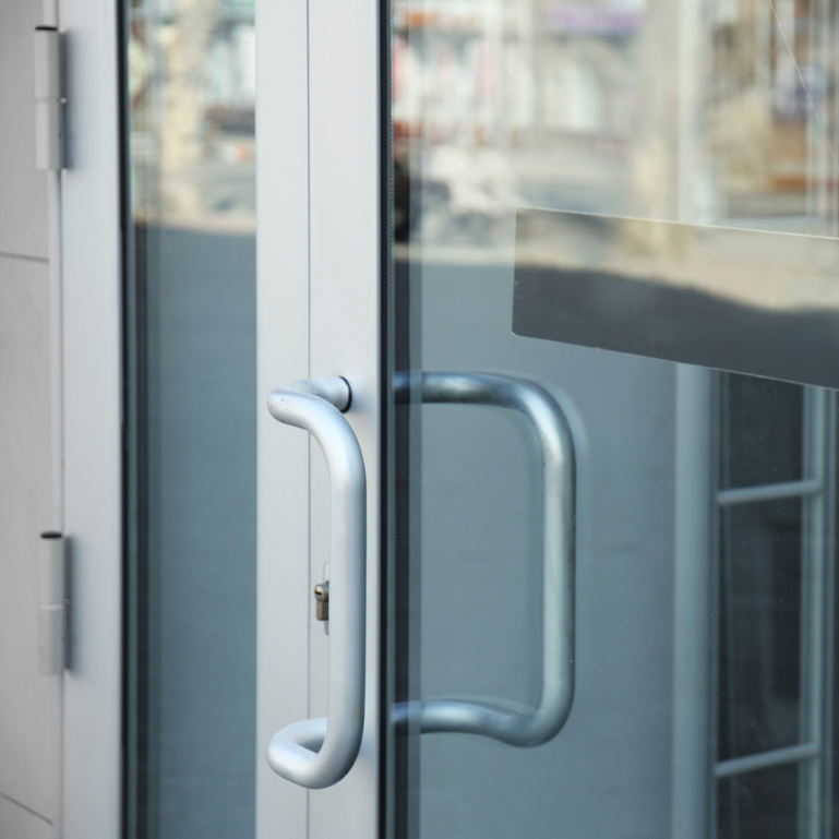 A close-up of a glass door with two handles