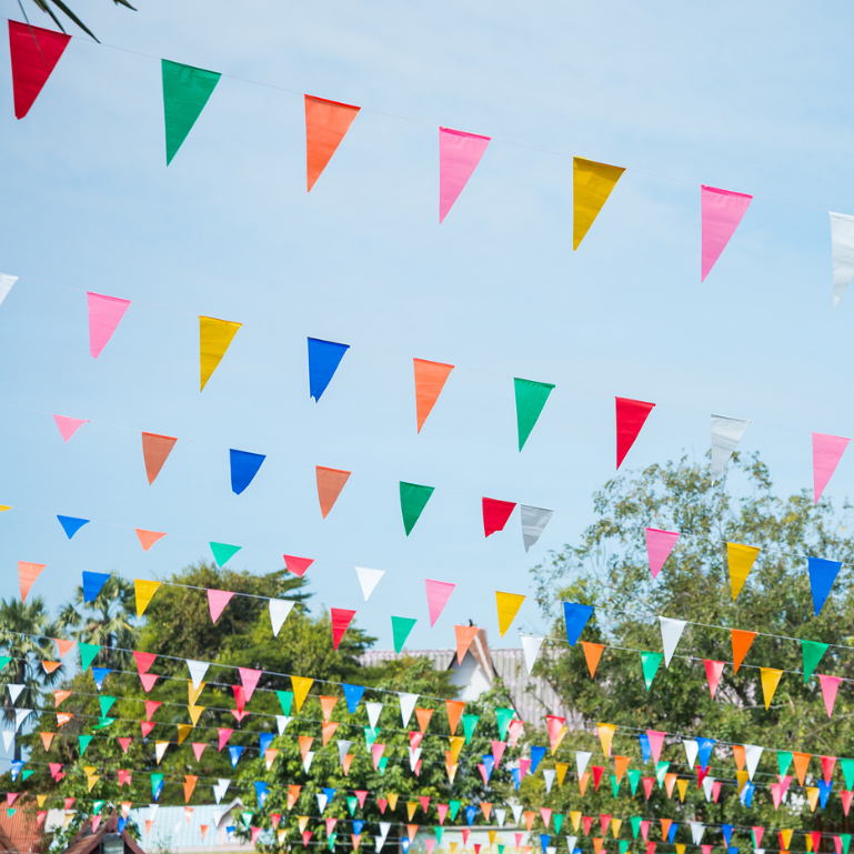 Colorful triangular flags hanging from a string against a blue sky
