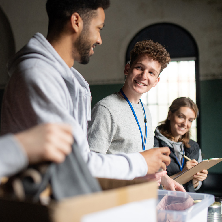 Group of young adults smiling and working together in a community event